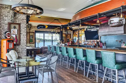 THE ULTIMATE ENTERTAINING HAVEN! FLOOR TO CEILING DOORS OPEN THE ENTIRE SPACE TO CAPTURE THE INDOOR POOL AND LAKE VIEWS. INDUSTRIAL LIGHT FIXTURES AND OVERHEAD VINTAGE "1955 MAHOGANY CHRIS CRAFT BOAT" CUSTOM CREATED HANGING CONVERSATION PIECE NOT TO MENTION THE ARCHITECTURAL CUSTOM BAR.  OVER THE TOP ATTENTION TO DETAIL....