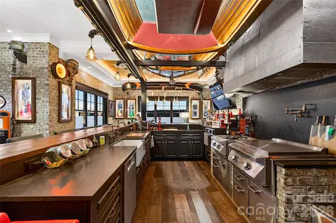 BAR KITCHEN IS FULLY EQUIPPED FEATURING PREMIUM STAINLESS STEEL COMMERCIAL APPLIANCES, CUSTOM VENT HOOD, FARMHOUSE SINK, EXTENSIVE BAR SEATING TO HANDLE GATHERINGS OF ANY SCALE INSTYLE!