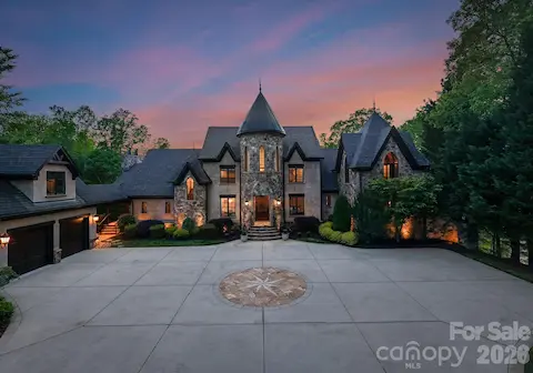 Pass through a private gate to arrive at this grand stone residence, where a nautical star design anchors the front driveway. A stately façade with arched entry and manicured landscaping warmly welcomes you home.