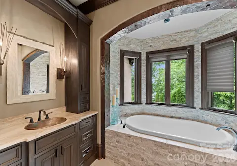 Spa bath with jetted tub, steam shower, and vanities.