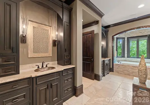 Spa bath with jetted tub, steam shower, and vanities.