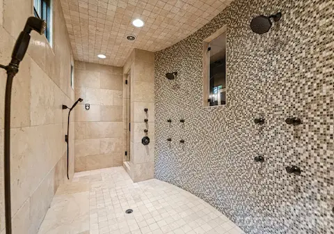Spa bath with jetted tub, steam shower, and vanities.
