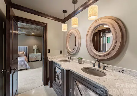 Jack-and-jill bathroom featuring dual vanities, an oversized walk-in shower and private water closet.