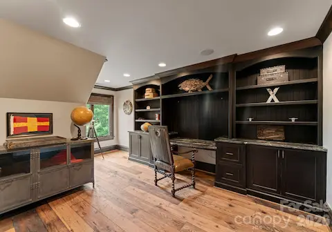 Upper-Level Office with built-ins and a ladder to the loft and attic storage.