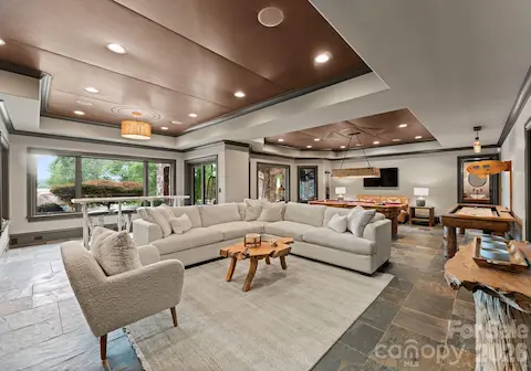 Lower-Level Living Roomis an open lounge space with TVs, billiards, and arcade games.