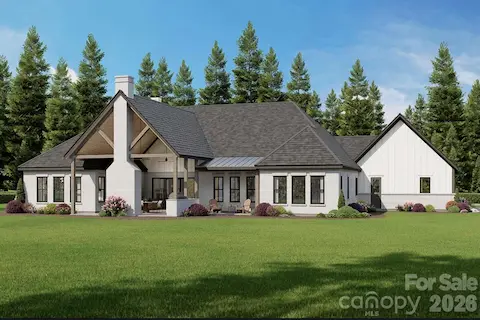 Spacious covered patio with exposed timber trusses and a brick fireplace, perfect for outdoor living and entertaining.