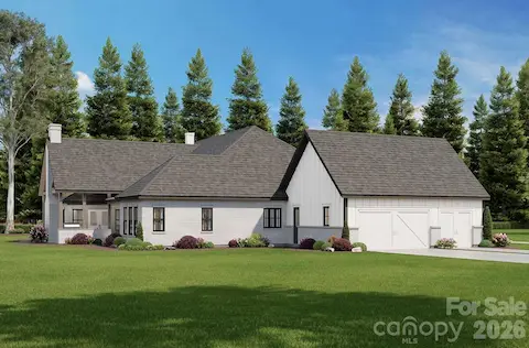 The combination of vertical board-and-batten siding, light-colored brick, and black-framed windows continues the elegant, contemporary farmhouse style.