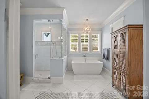 Spa-like bathroom features a freestanding soaking tub, walk-in glass shower, and abundant natural light.
