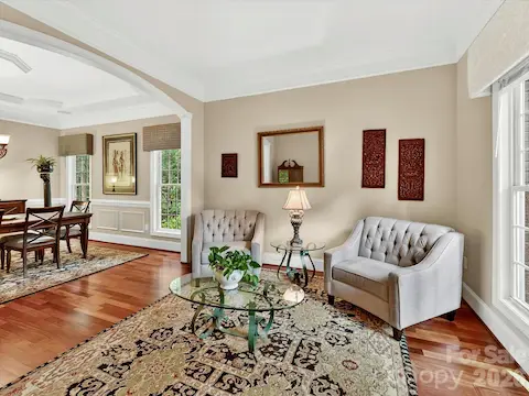 Stately living room features rich hardwood floors, abundant natural light, and an open flow ideal for both everyday living and entertaining.