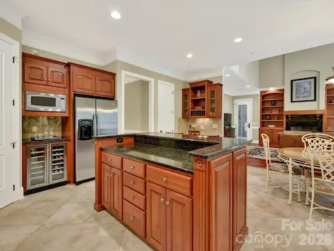 Chef’s kitchen showcases rich custom cabinetry, granite countertops, stainless steel appliances, a large center island, and an open layout designed for effortless entertaining.