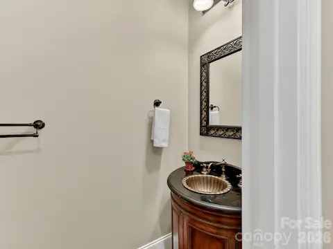 Stylish powder room features an elegant furniture-style vanity, designer fixtures, and upscale finishes perfect for guests.