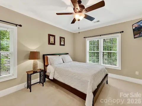 Spacious secondary bedroom features large windows, soft natural light, and a private en-suite bath for added comfort and convenience.