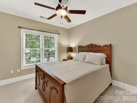 Bright and spacious secondary bedroom features large windows, neutral tones, and a comfortable layout perfect for family or guests.