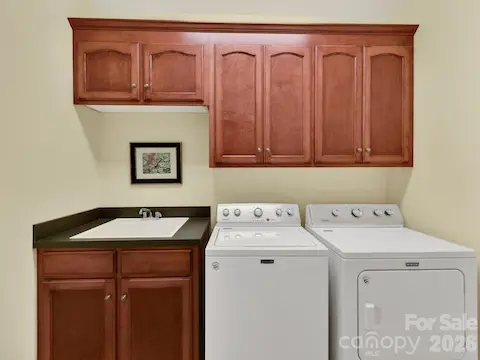 Functional laundry room features built-in cabinetry, utility sink, and ample storage to keep everyday tasks organized and efficient.