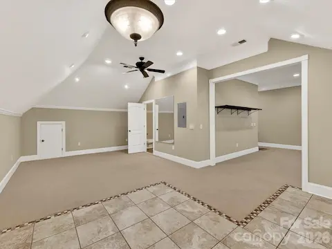 Expansive third-level bonus room offers incredible flexibility with vaulted ceilings, recessed lighting, built-in wet bar, and abundant space for entertaining, recreation, or a home theater.