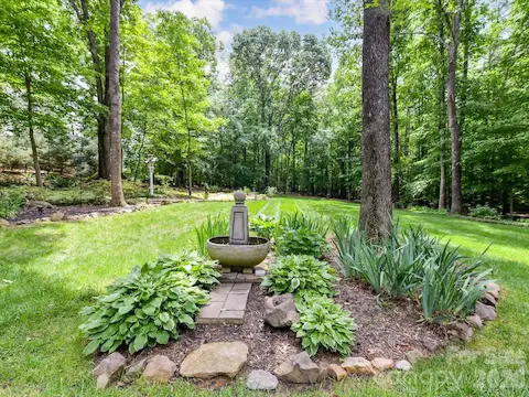 Beautifully landscaped backyard oasis features lush gardens, mature trees, and a serene, park-like setting for outdoor enjoyment.