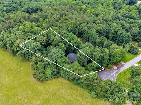 Aerial views showcase the home’s exceptional privacy, surrounded by mature trees on a beautifully wooded lot.