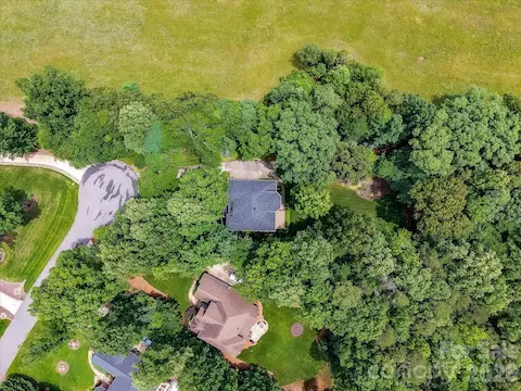 Drone views highlight the home’s serene wooded setting, mature landscaping, and exceptional privacy on a spacious lot.