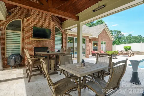 This covered area is heated, enjoys a double-sided fireplace and view of the pool
