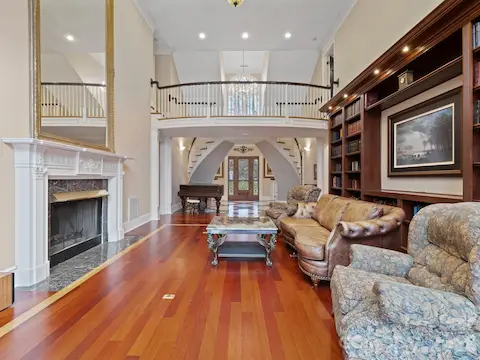 Soaring two stories high, the great room is adorned with exquisite built-in cabinetry illuminated by gentle downlighting, Brazilian Cherry floors framed with a contrasting inset, and a welcoming fireplace.