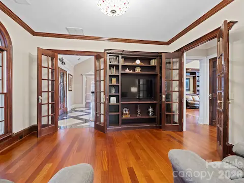 Sophisticated executive office with detailed dental crown molding and elegant double French doors.