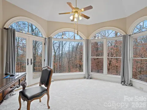 From the sitting area in the primary bedroom, peaceful views of water and trees greet you each morning.