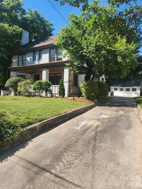 view from street, with private driveway as well as garage parking in the rear of home