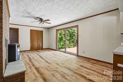 Bright living area with fresh LVP flooring and cozy atmosphere, flowing seamlessly into the kitchen, featuring a built-in desk for work or study.