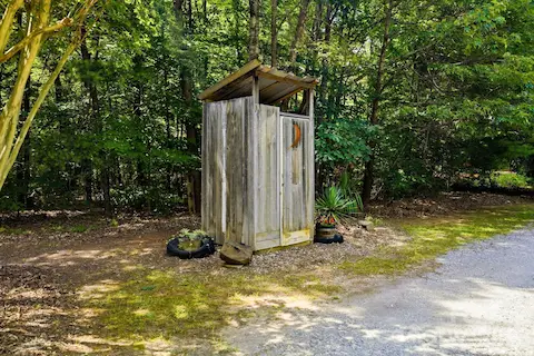Classic outhouse adds character and a touch of rustic charm to the property.