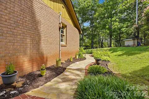 Stone walkway wrapping around the home and leading to the screened porch, creating an easy and inviting connection to outdoor living spaces.