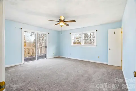 Primary bedroom with private deck access, offering peaceful views and a serene retreat.