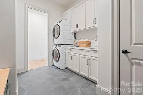 Laundry room includes drop-zone area, cabinets, sink and closet