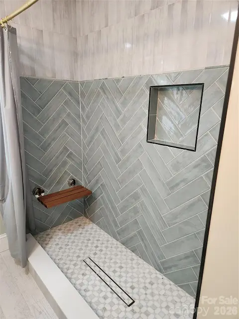 Upstairs lovely tiled shower with built in shower bench