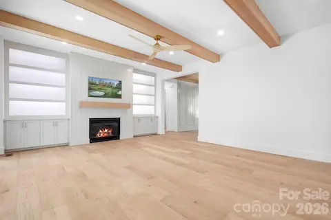 Family Room with lit Built-ins and beam ceiling