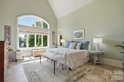 Main floor primary suite with tile floors, glass door opening to screen porch and pasture views