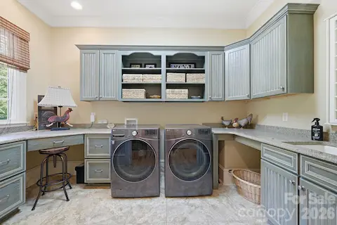 Main floor laundry room and office with built-in desk, file cabinets and sink