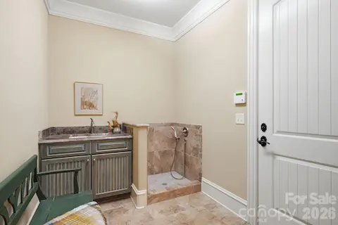 Mud room with cabinet and sink.  Dog shower or muddy boot bath off lower level oversized garage