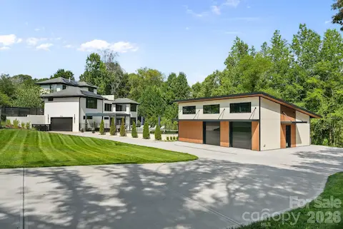 Custom rear-entry garage with oversized circular driveway and gated entry