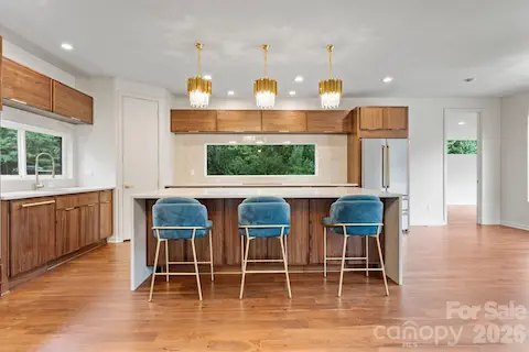 Modern chef's kitchen with waterfall quartz island, custom oak cabinetry, and pro-grade stainless appliances