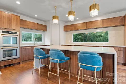 Open-concept gourmet kitchen with breakfast bar seating and designer stainless appliance suite