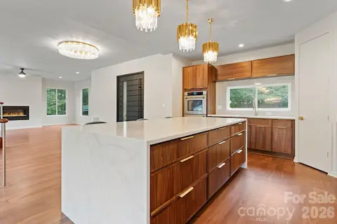 Luxury kitchen featuring custom oak cabinetry, full backsplash, and high-end stainless steel appliances