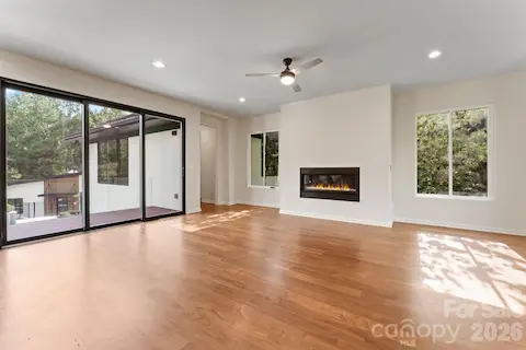 Bright open-concept living room with oak hardwood floors and cozy gas fireplace