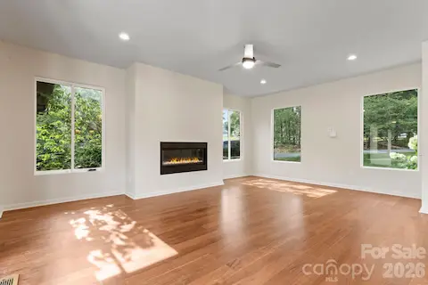 Open living area with oak hardwood floors, gas fireplace, and tons of natural light