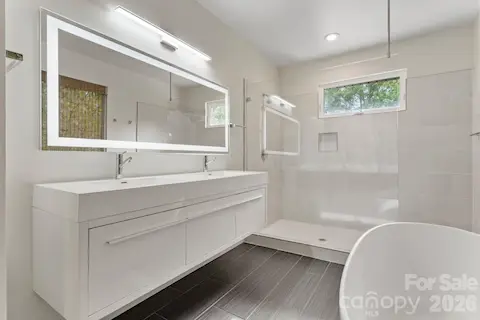 Luxury primary spa bathroom with oversized walk-in shower and freestanding soaker tub