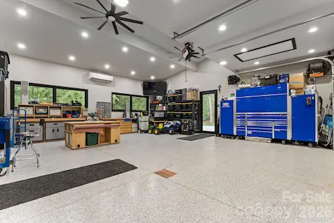 Oversized heated and cooled garage with polyaspartic floor coating, EV charger, hot/cold faucets, and plumbed pressure washer