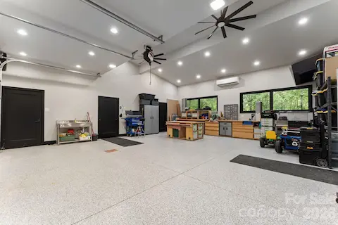 Oversized heated and cooled garage with polyaspartic floor coating, EV charger, hot/cold faucets, and plumbed pressure washer