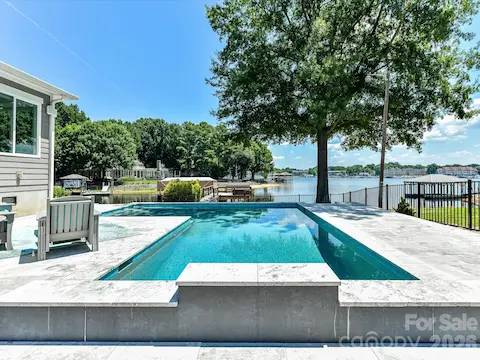 Resort-style pool with expansive sun deck overlooks beautiful Lake Norman, creating the perfect setting for relaxation, entertaining, and enjoying breathtaking waterfront views.