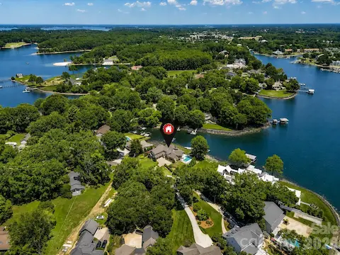 Aerial view showcases the home's premier waterfront location on a quiet Lake Norman cove with expansive water views and a beautifully landscaped setting. (Virtually enhanced lake levels)