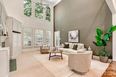 Wall of windows, plantation shutters & a striking accent wall create a warm, inviting space.