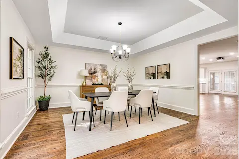 Freshly painted formal dining room with refinished hardwoods & tray ceiling.